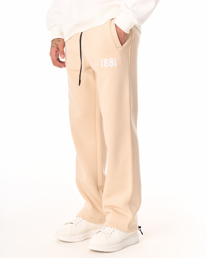 Martin Valen 1881 oversized beige jogger, close-up of waist with black drawcord and white embroidered 1881 logo
