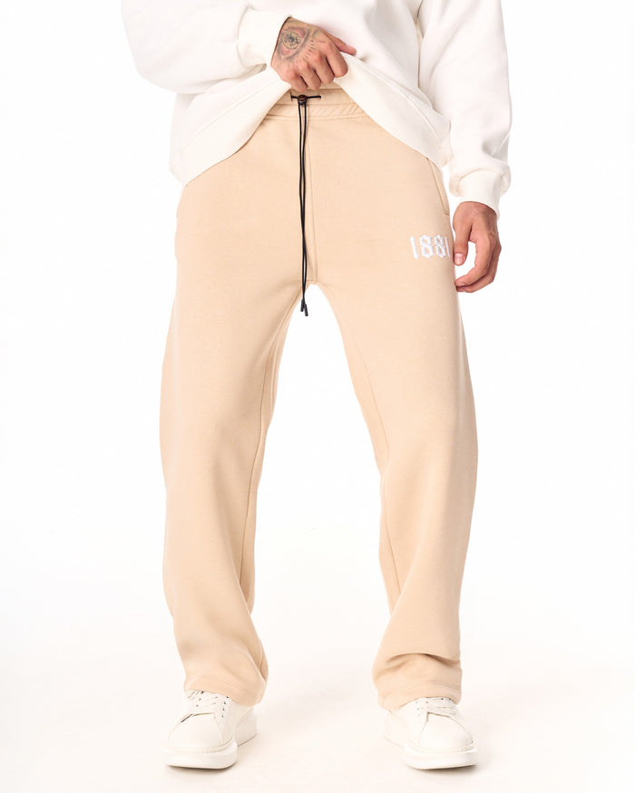 Martin Valen 1881 oversized beige jogger, front view showing full leg and hem falling over white sneakers