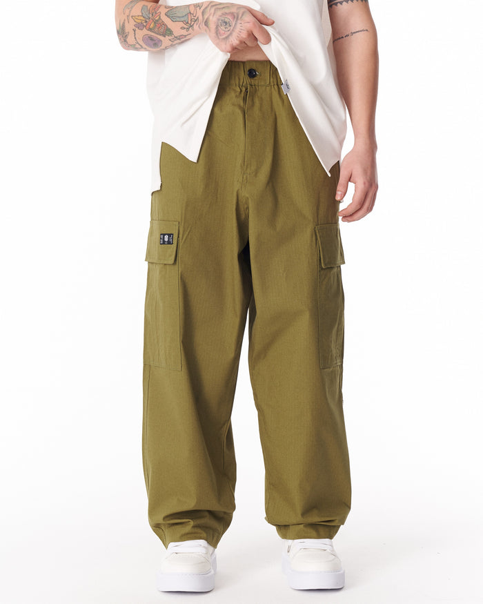 Martin Valen khaki wide-leg trousers, front waist detail with button and elasticated waistband shown under lifted t‑shirt