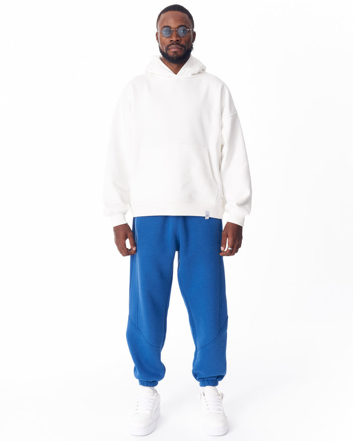 Martin Valen full blue joggers, full-length front view showing curved stitch panels, gathered ankles and white sneakers