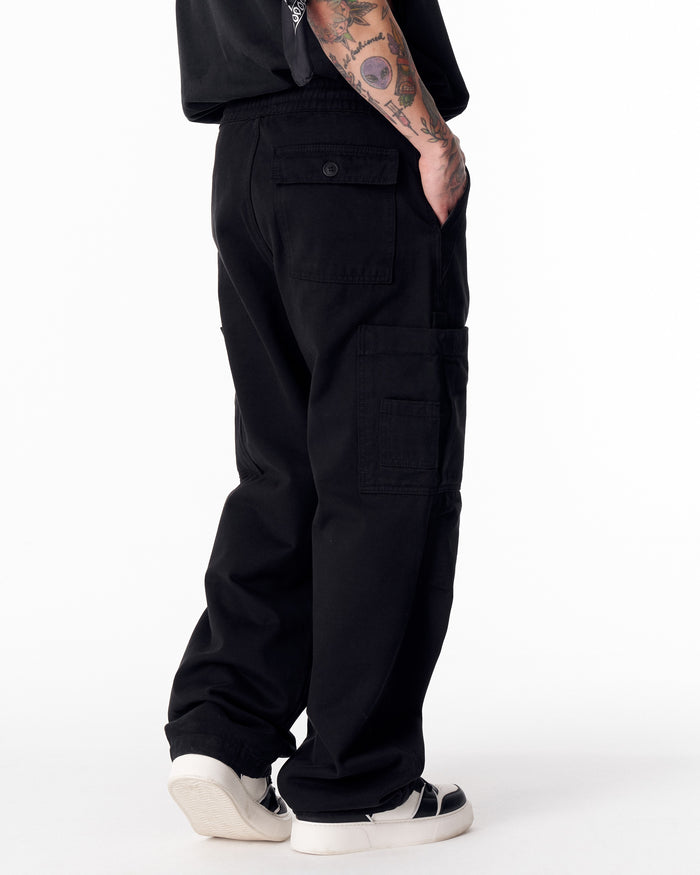 Martin Valen men's oversize black cargo jogger pants, full front view showing wide legs and black-and-white sneakers